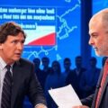 Two men resembling Tucker Carlson and Mark Levin engage in a tense debate in a professional broadcast studio, with “MAGA” symbolism subtly present and “Iran War” displayed prominently on screens behind them.