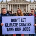 National conservative protesters, carrying a sign protesting action on climate change and decarbonization
