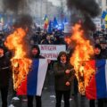 Moldova protesters burning Russian flags, showing the victory in the election over Russian interference